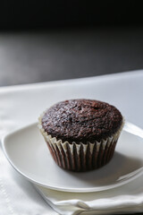Delicious and fresh chocolate muffins on a gray ceramic table.