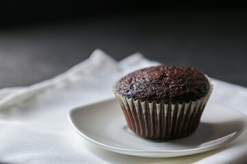 Delicious and fresh chocolate muffins on a gray ceramic table.