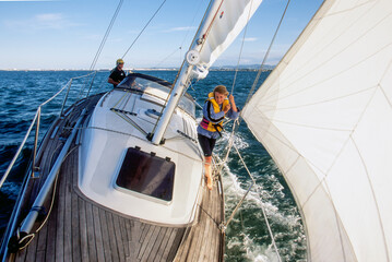 Father and young daughter on yacht sailing on calm water