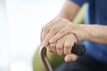 杖をつき座る高齢者の手元