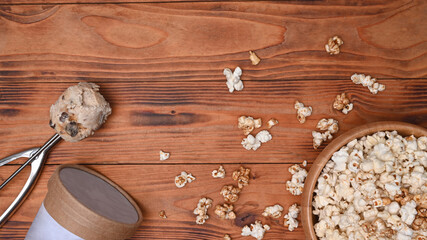 Popcorn bowl and ice cream and on wooden background.