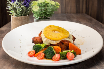 Western food. Hawaiian Chicken Chop. Grilled Chicken Chop. Pineapple. Cheese. Broccoli. Tomato. Carrot. Mashed Potato. Close up of chicken chop. Café or restaurant background. Dinner or lunch.