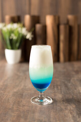 Chamomile blue and passion fruit mocktail with wood and plant as background