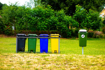 Plastic waste bins for separated waste on the beach by the lake
