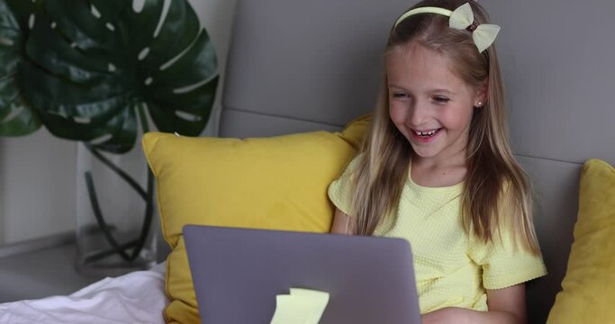 Caucasian little girl school pupil studying online from home, watching web class lesson or listening tutor by video call elearning during coronavirus covid-19 pandemic self isolation. Slow motion