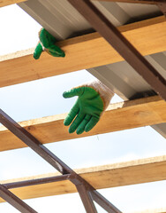 Workers install a metal shed on a wooden frame.