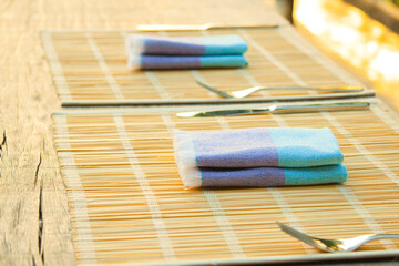 Obraz na płótnie Canvas Breakfast table setting with bamboo, fork, napkin and knife