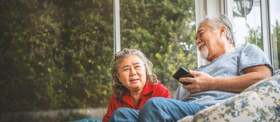 Couple elderly sit rest and talking on the sofa in the living room.