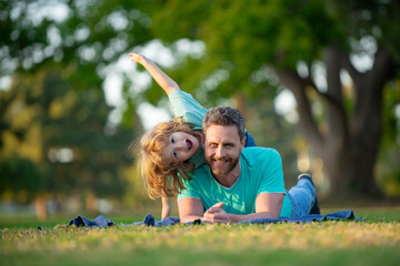 Naklejka premium Happy father and son enjoying summer time on vacation in a sunny park. Concept of healthy holiday and family activity.