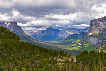 A panoramic view of a valley in Glacier National Park covered by Clouds