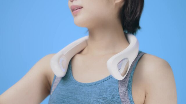 ネックファンを使う女性　首かけ式ポータブル扇風機