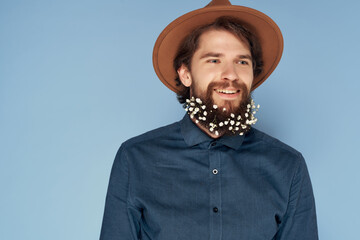 Cheerful man in a hat flowers in a beard fashion modern style isolated background