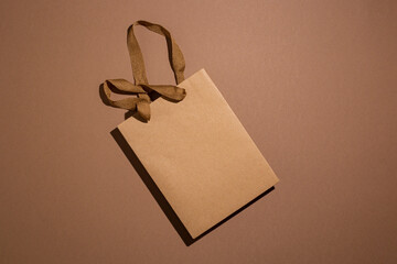 One package of gift craft brown on brown craft background. Top view, flat lay