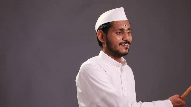 Young indian man (pilgrim) in traditional wear and waving religious flag.