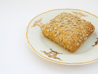 Sunflower bun on porcelain decorated plate on white background