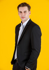 Portrait half body of handsome and executive look french businessman in black suit pose in boss action and positive smile face. Successful and happy business man concept on yellow background