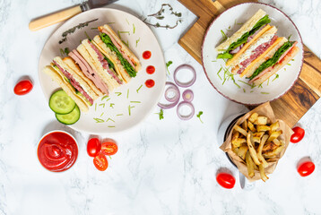 club sandwich with ham, tomatoes, lettuce and mayonnaise between slices of  bread 