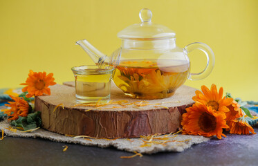 Herbal tee with nasturtium flovers on a yellow background.