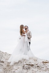 Fototapeta na wymiar Beautiful wedding couple bride and groom at wedding day outdoors at ocean beach. Happy marriage couple o