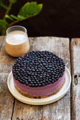 Vegan blueberry cheesecake. Wooden background, side view.