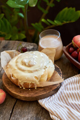 Buns with peaches and white chocolate. Fruits, coffee, wooden background, side view.