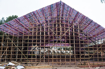 Asian people macanese workers working builder new building with bamboo scaffolding in construction site in Senado Senate Square at Macao Special Administrative Region on April 19, 2015 in Macau, China