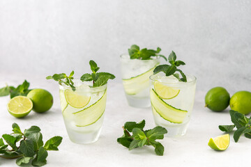 Cold refreshing drinks with lime and cucumber, summer iced beverage and fresh green mint, glasses with lemon water