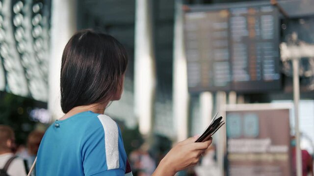 Travel woman checking boarding pass arrival departure board schedule terminal international airport