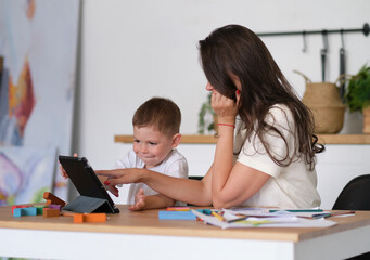 Mother with young boy using digital tablet.happy mom and baby play educational online games on the tablet.