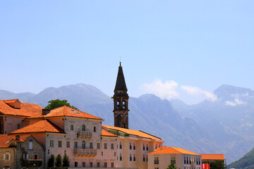 Naklejka premium Old Historic buildings and towers in Perast, Montenegro. A beautiful town in Kotor Bay in summer near high mountains. Adriatic Sea, Montenegro