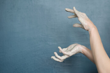 female hands clotted mud clay play cheerfully and show hands. Hands dirty