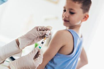 Coronavirus vaccination. Covid-19 vaccine. Doctor vaccinating child. Little boy getting flu shot.