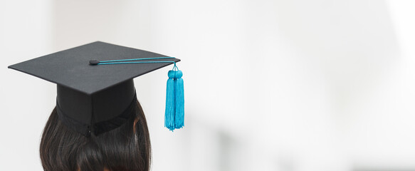 Close-up shot of a university graduate in graduation gown holding a degree certification with...