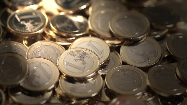 Euro coins falling down over many pieces. Back light effect. Closeup view and soft focus