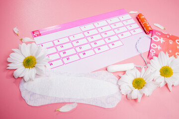 Menstruation calendar with cotton tampons , sanitary pads, white flower . Woman critical days,...