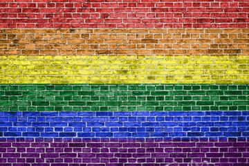 Brick wall painted in lgbt flag colours with copy space