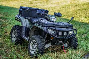 ATV quad bike on a background of green grass. Four-wheeled motorcycle 4x4 for sports and recreation. Off-road transport.