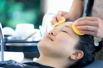 Obraz na płótnie Canvas Asian girl beautiful skin is sleeping for the staff to use the puff to gently clean the face. 