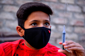 13 years old Asian cute boy wearing protective mask, with syringe, prevention of Corona virus...