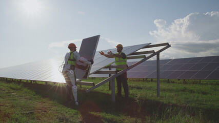 Male engineers installing solar panels together