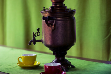 Russian copper samovar and tea cups on the table in the gazebo