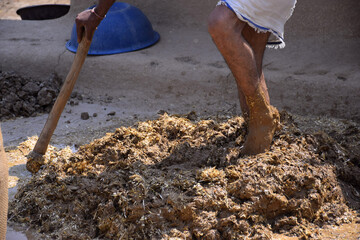 feet of a man while trampling the soil to build a wall