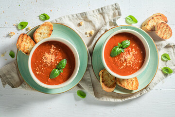 Hot tomato soup with toasts and basil. Soup with croutons.