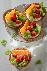 Homemade mini tart with fruits and cream. Simple summer dessert.