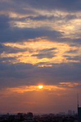 兵庫県神戸市東灘区の高層マンションの上層階からの夜明け。大阪生駒山から太陽が昇り、あたりはオレンジ色に染まり、ビル群がシルエットで浮かぶ