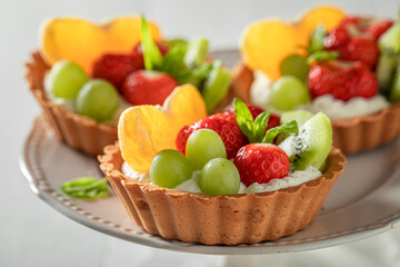 Sweet mini tart with fruits and cream. Sweet fruit dessert.