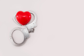 red heart and handcuffs on a white background