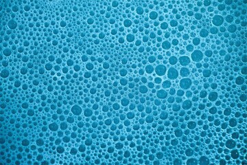 Blue bubbles background with space for text.  Isolated fizzy pattern having three-dimensional surface, closeup.
