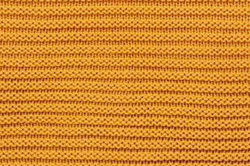 Macro view Yellow synthetic knitted fabric close up.  Knitting pattern of wool. Knitting Horizontal orientation Yellow wool texture background