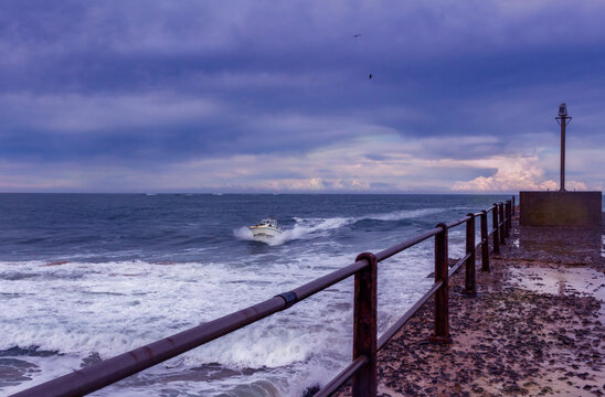 Fishing motor boat coming into shore at Port Alfred on a cold stormy late afternoon